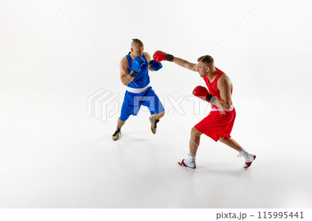 Action shot of two fighters, exchanging blows and testing their endurance in sparring session against white studio background. Action shot of two fighters, exchanging blows and testing their endurance in sparring session against white studio background. 115995441