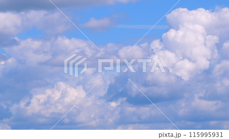 Floating fluffy clouds. Two layers of cloudiness. Blue summer sky with clouds moving in different directions. Time lapse. 115995931