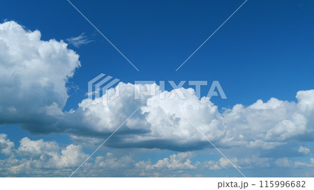 Clouds running across the blue sky. White puffy and fluffy clouds on blue sky. Time lapse. 115996682