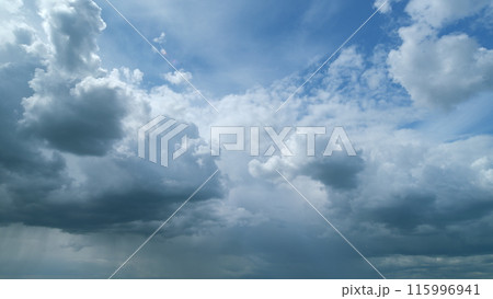 Sky before storm. Stormy cloudy sky wide panorama. Storm cloudy dramatic sky with dark rain grey cumulus cloud and blue sky. Timelapse. 115996941