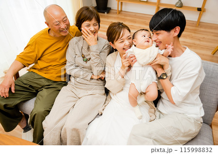 自宅のリビングで団らんするシニアの祖父母と0歳の赤ちゃんと両親の3世帯5人の大人数のファミリー 115998832
