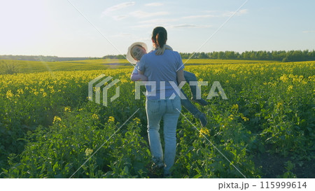 Happy Family Together Outdoors In Golden Rapeseed Field. Family Lifestyle Mom Takes Care Of Son Childhood. Concept Of Childhood. Happy Family Together Outdoors In Golden Rapeseed Field. Family Lifestyle Mom Takes Care Of Son Childhood. Concept Of Childhood. 115999614
