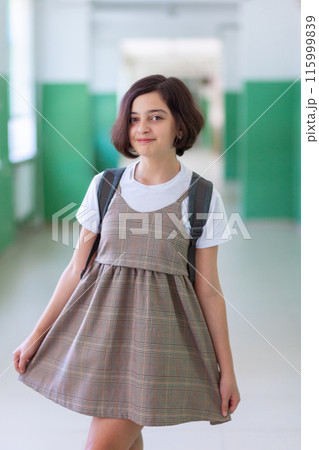 Beautiful girl in a school corridor posing for the camera Beautiful girl in a school corridor posing for the camera 115999839