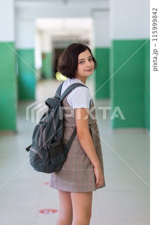 Beautiful girl in a school corridor posing for the camera Beautiful girl in a school corridor posing for the camera 115999842