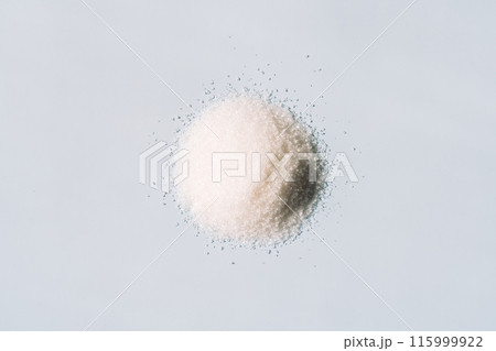 Pile of crumbly white sugar on blue background 115999922