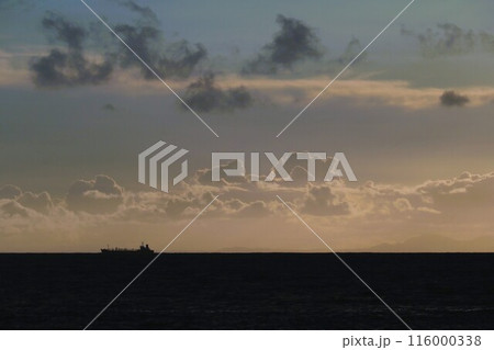 日が沈み暮れてゆく空と暗い海　遠くを進む船のシルエット 116000338