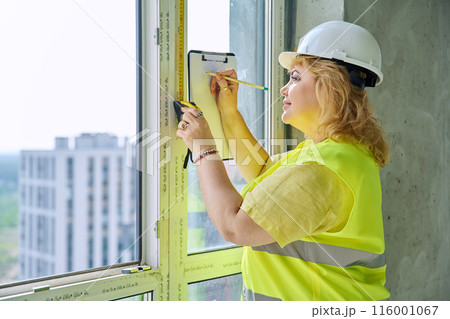 Female window decorator designer measuring window with tape measure Female window decorator designer measuring window with tape measure 116001067