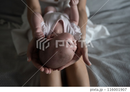little cute baby girl lies in her mother's arms 116001907