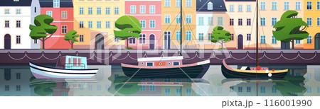 Colorful waterfront scene with boats docked along a canal lined with vibrant buildings and lush trees reflecting in the water Colorful waterfront scene with boats docked along a canal lined with vibrant buildings and lush trees reflecting in the water 116001990