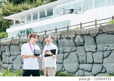 屋外でドローンを使った撮影を行う映像クリエイター 116004733