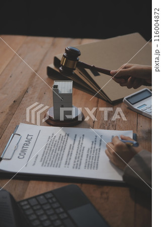 Real Estate Law, Home Insurance, property Tax, Auction and Bidding concepts. small toy house model with gavel justice hammer on desk in courthouse. 116004872