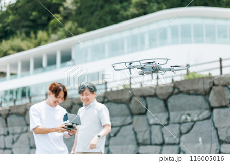 屋外でドローンを使った撮影を行う映像クリエイター 116005016