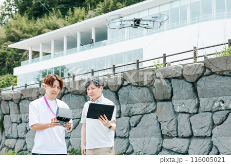 屋外でドローンを使った撮影を行う映像クリエイター 116005021