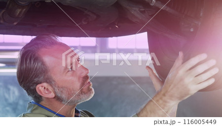The mechanic is checking the tire pressure in the garage The mechanic is checking the tire pressure in the garage 116005449