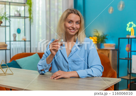 Thirsty woman hold glass of natural filtered aqua makes sips drinking still water good life habits 116006010