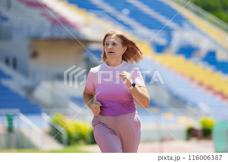 Elderly woman exercising. Fit senior lady running. 116006387