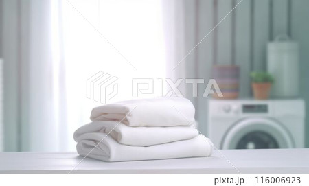 Folded white towels on countertop with laundry machine in background. AIG35. 116006923