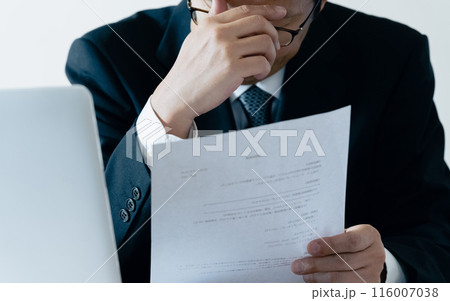 書類を見て悩む採用担当の男性 書類を見て悩む採用担当の男性 116007038