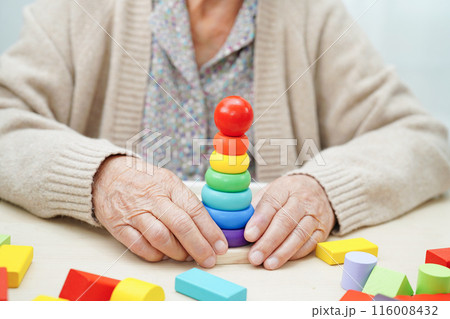Asian elderly woman playing puzzles game for treatment dementia prevention and Alzheimer disease. Asian elderly woman playing puzzles game for treatment dementia prevention and Alzheimer disease. 116008432