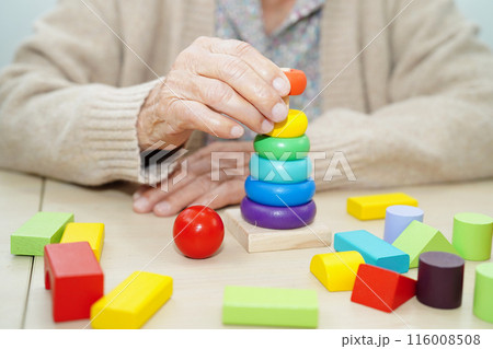Asian elderly woman playing puzzles game for treatment dementia prevention and Alzheimer disease. Asian elderly woman playing puzzles game for treatment dementia prevention and Alzheimer disease. 116008508