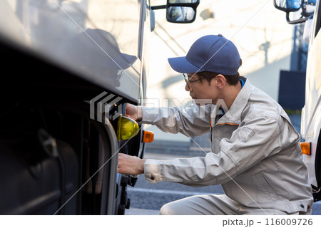 タイヤの点検をする男性トラックドライバー 116009726