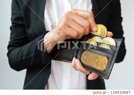 Cropped shot of businessperson collecting golden Bitcoin token in leather wallet. Bitcoin is one of the popular cryptocurrency, a virtual currency or a digital currency. 116010667