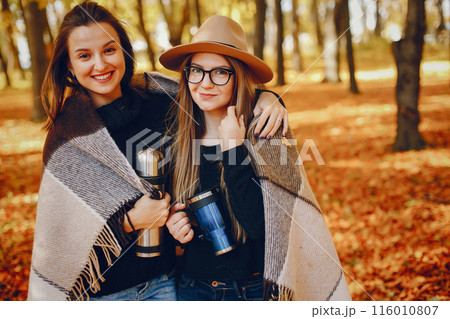 Beautiful girls in a park. Cute ladies in a stylish clothes. 116010807