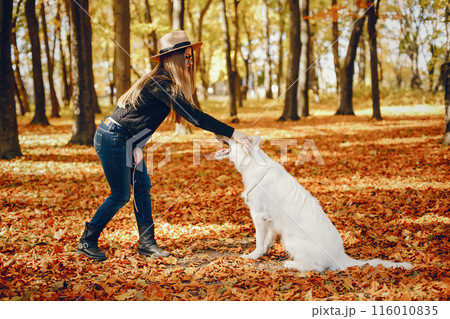 Beautiful girls in a park. Cute ladies in a stylish clothes. Girl with cute dog Beautiful girls in a park. Cute ladies in a stylish clothes. Girl with cute dog 116010835
