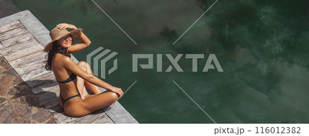 Woman Smiling by Pool with Sun Hat 116012382