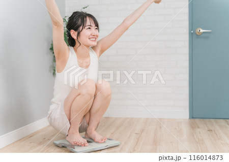 体重計に乗るスリムなアジア人女性(ダイエット・痩身イメージ) 116014873