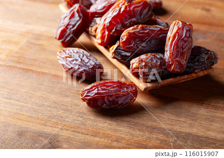 Juicy dates on a old wooden table. 116015907