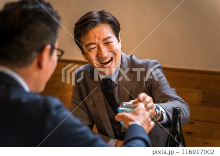 居酒屋・飲み屋でお猪口で乾杯するサラリーマン（飲みニケーション・飲み会） 116017002