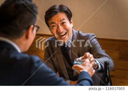 居酒屋・飲み屋でお猪口で乾杯するサラリーマン（酔っ払い・からみ酒） 116017003