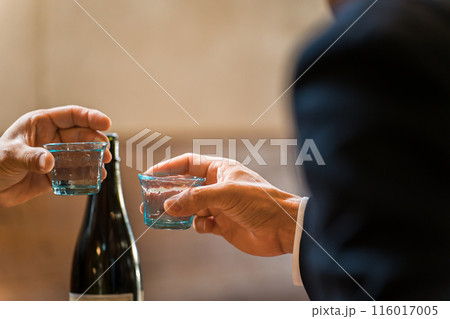 居酒屋・飲み屋でお猪口で乾杯するサラリーマンの手元 116017005