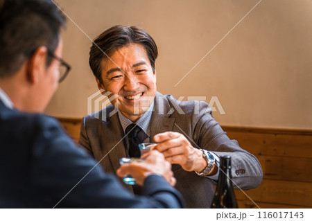 居酒屋・飲み屋で部下・同僚と楽しくお酒を飲む中年のアジア人ビジネスマン 居酒屋・飲み屋で部下・同僚と楽しくお酒を飲む中年のアジア人ビジネスマン 116017143