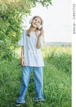 A child  with headphones listening to music and dancing . 116017152