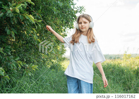 A child  with headphones listening to music and dancing 116017162