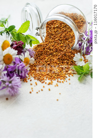 Healthy bee pollen grains. Bee pollen on a glass jar and wild flowers.. Healthy bee pollen grains. Bee pollen on a glass jar and wild flowers.. 116017170