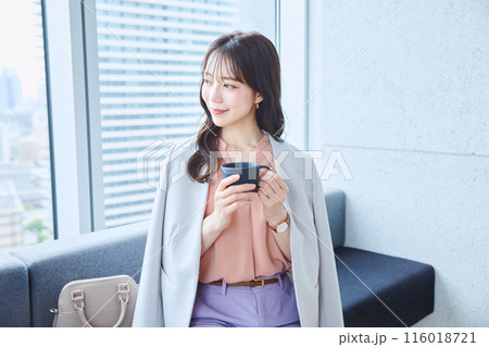 オフィスのソファでコーヒーを飲む女性 116018721