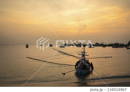Fishing Wood boat on peaceful calm relaxing on the water and dramatic clouds at Sunset Fishing Wood boat on peaceful calm relaxing on the water and dramatic clouds at Sunset 116018967
