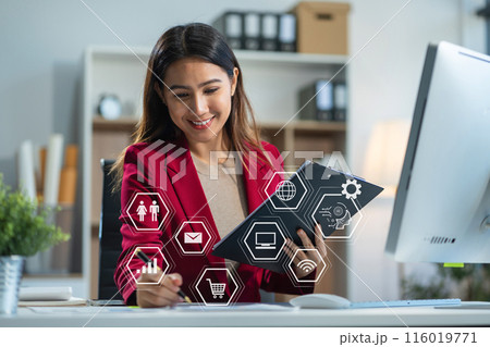 Businesswomen using tablet with laptop and document on desk in modern office with virtual interface graphic icons network diagram. Businesswomen using tablet with laptop and document on desk in modern office with virtual interface graphic icons network diagram. 116019771
