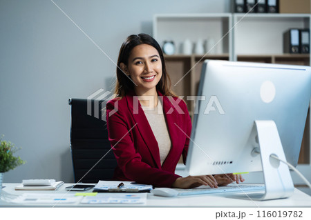 Female asian sitting at the desk, looking to camera. 116019782
