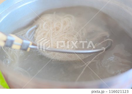 大鍋で茹でているそうめんを掬っている様子 116021123