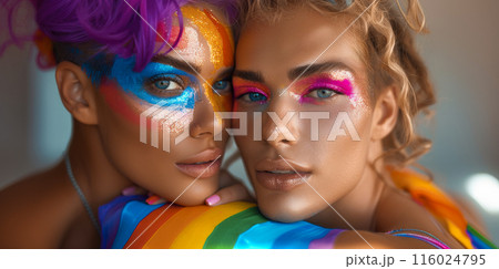 Young people bright make up standing next to each other smiling. One has iridescent paint on face 116024795