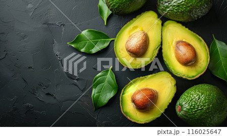 Sliced avocados oil placed on stone surface among green leaves, top view gray table whole avocado Sliced avocados oil placed on stone surface among green leaves, top view gray table whole avocado 116025647