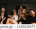 Women learn to play video games on console with friends 116028475