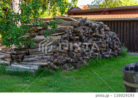 Old house with beautiful garden, and pile of firewood. 116029193