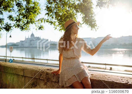 Young female tourist enjoys view of city at sunset. Euro-trip. Travel, tourism, lifestyle concept. 116030670