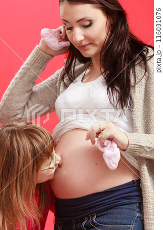 Daughter kissing her pregnant mother belly 116031076