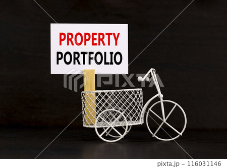 Property portfolio symbol. Concept words Property portfolio on beautiful white paper on wooden clothespin. Beautiful black background. Bike model. Business Property portfolio concept. Copy space. 116031146